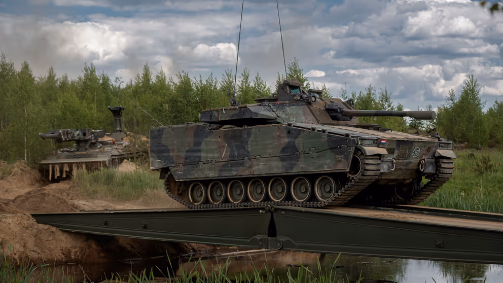 Een tank rijdt over een tijdelijke brug