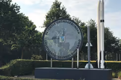 Logo Defensiegebonden Luchtverdedigingscommando, met daarnaast twee raketten