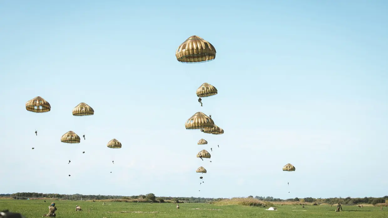 Een tiental parachutisten in de lucht