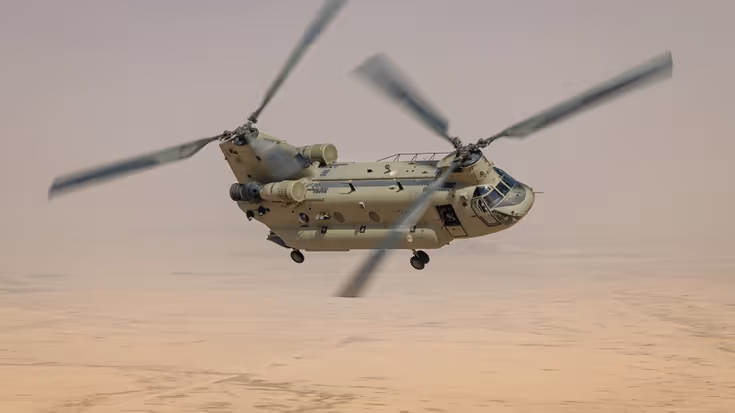 Chinook transporthelikopter vliegt in de lucht boven woestijn.