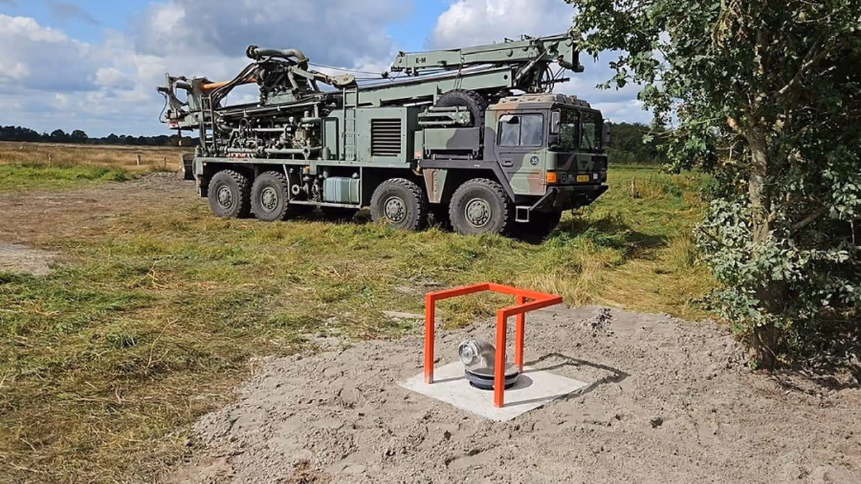 Militair voertuig naast een geslagen waterput.
