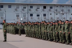 Rijen opgestelde militairen op een plein.