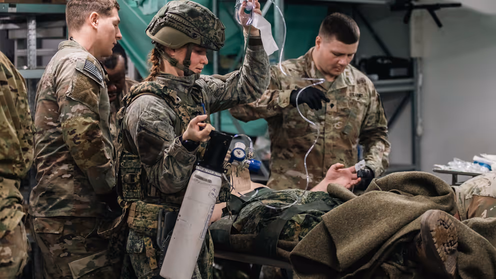 Geneeskundig personeel stabiliseert 2 door een voertuigcrash gewond geraakte soldaten.