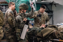 Geneeskundig personeel stabiliseert 2 door een voertuigcrash gewond geraakte soldaten.