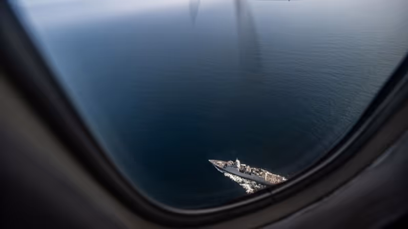 Foto vanuit kustwachtvliegtuig van schip op zee.