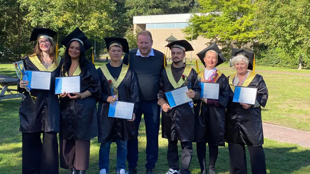 Nieuwe koks poseren met hun diploma's.