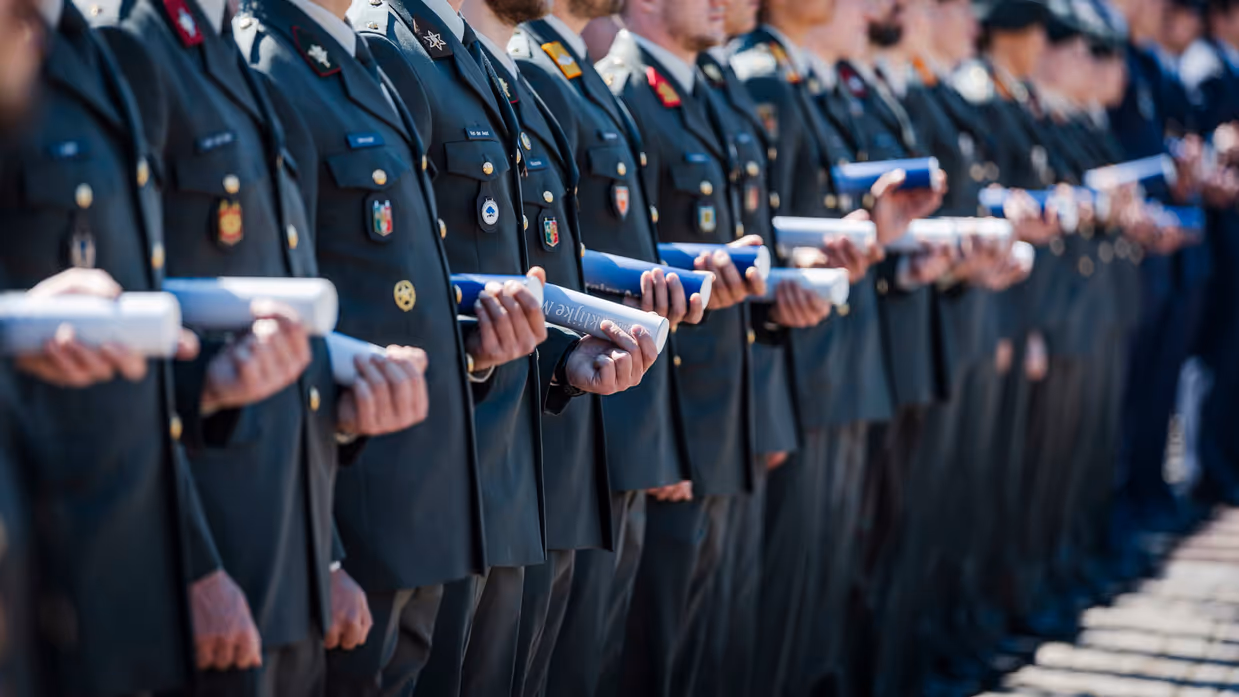 Cadetten op een rij die hun bul vasthouden onder de arm.