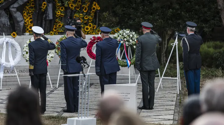 Militairen salueren bij een herdenking.