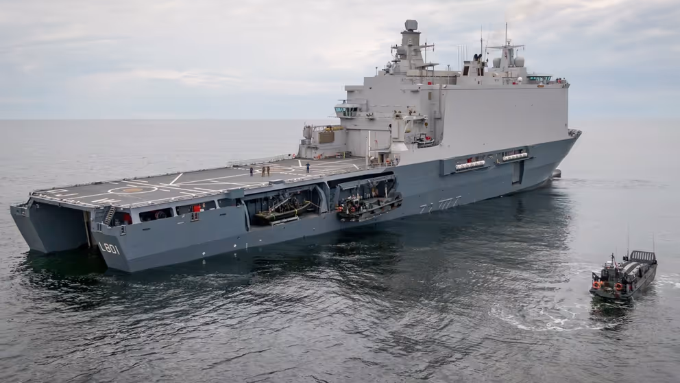 Marineschip op open zee, schuin van achteren gezien.