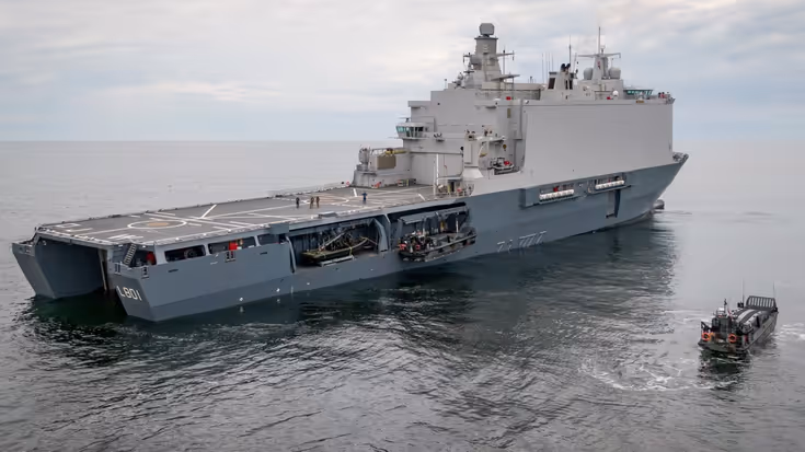 Marineschip op open zee, schuin van achteren gezien.